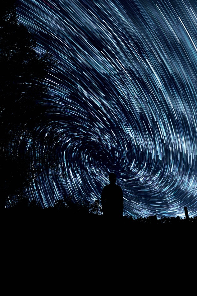Man standing in front of a vortex of stars